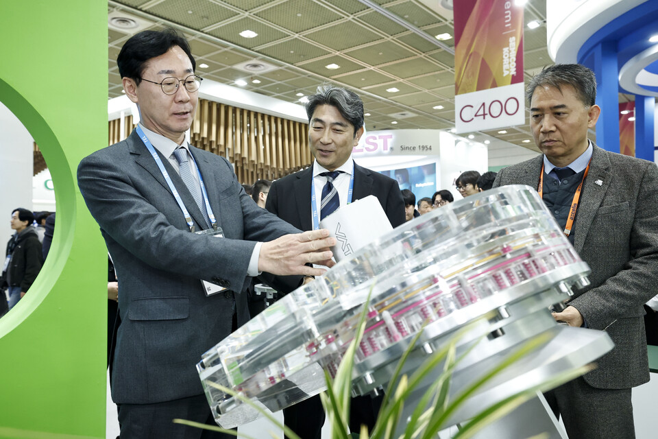 ▲ 정명근 화성특례시장이 2월 12일 서울 코엑스에서 열린 ‘세미콘 코리아 2026’ 참관 도중 반도체 장비 모형을 살펴보며 기업 관계자와 기술 현황에 대해 의견을 나누고 있다.